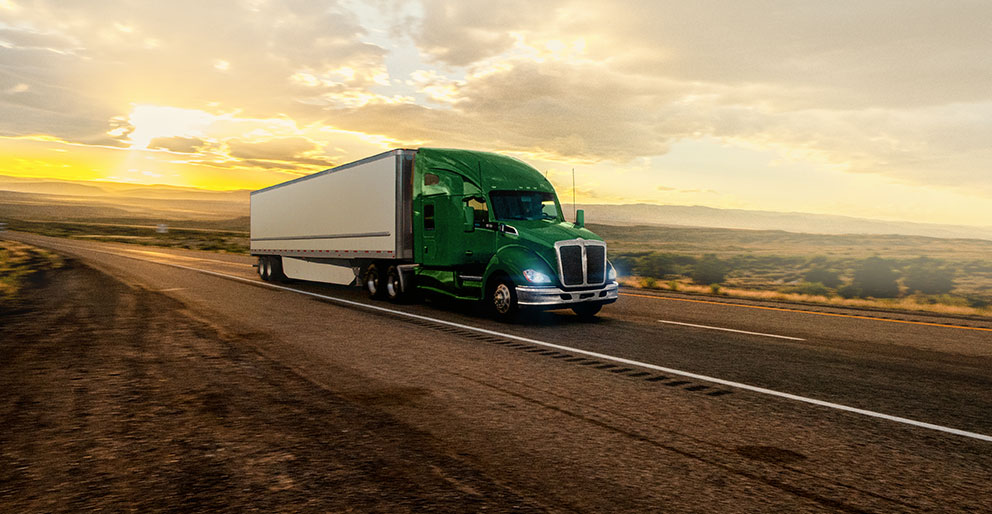 A transport truck and trailer driving on the highway transporting freight